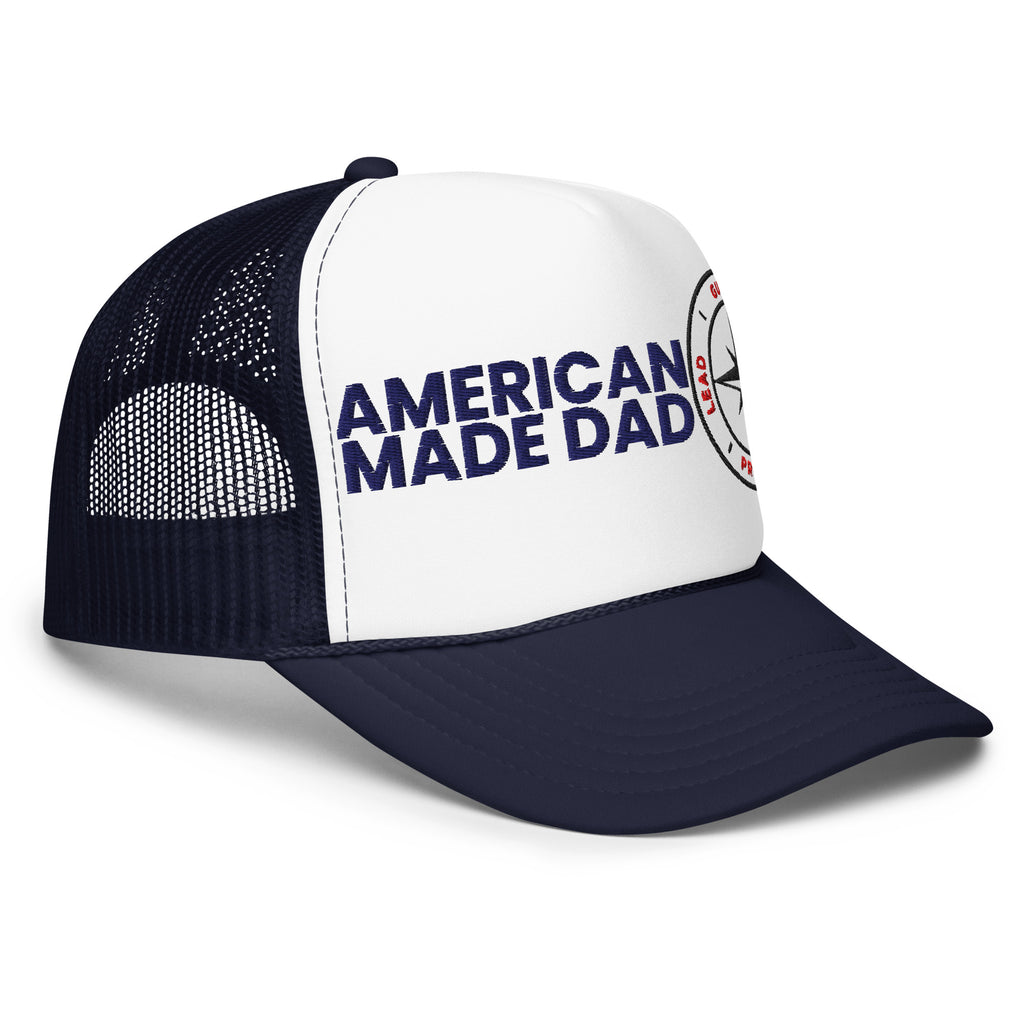 Right angle of a navy and white foam trucker hat with the American Made Dad compass