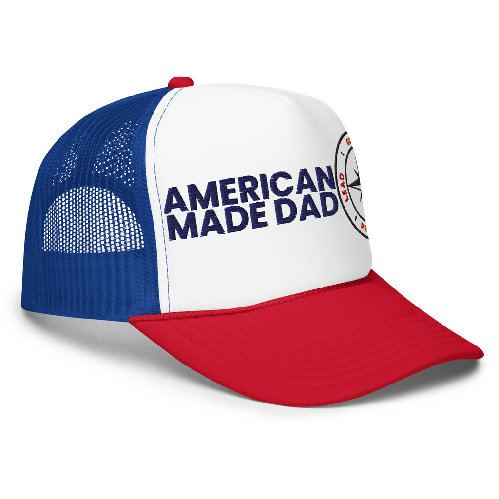 Right angle of a red, white and royal foam trucker hat with the American Made Dad compass