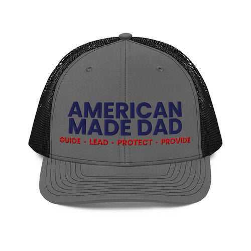Front of a charcoal and black snapback trucker cap with the embroidered American Made Dad compass