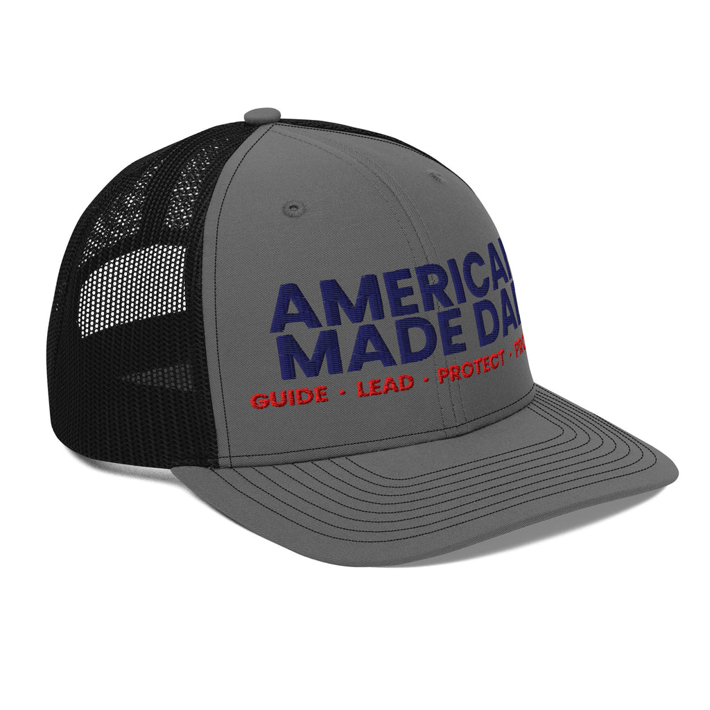 Right angle of a charcoal and black snapback trucker cap with the embroidered compass on the front